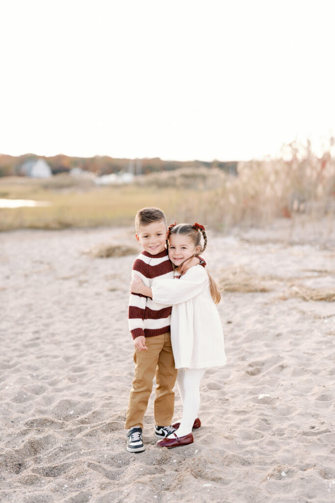 Family of four enjoying a sunset beach session in Guilford Connecticut with soft coastal light and ocean views