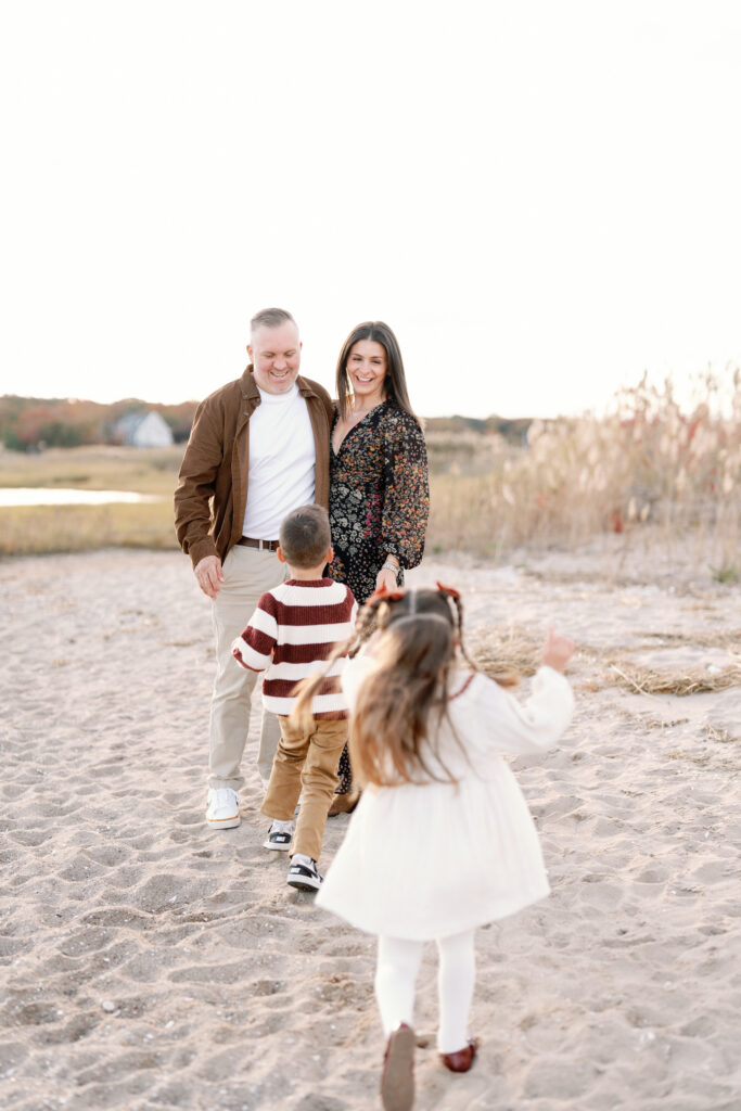 Family of four enjoying a sunset beach session in Guilford Connecticut with soft coastal light and ocean views
